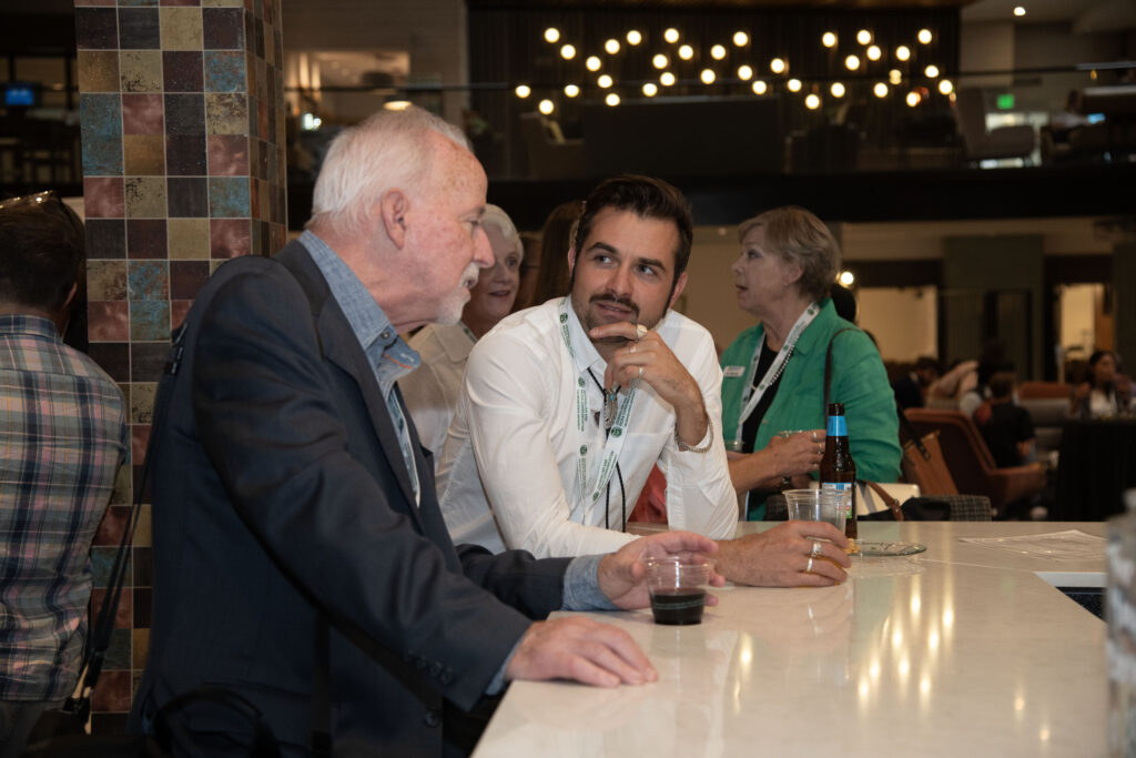 Two attendees talking during an evening reception at Local News Solutions.