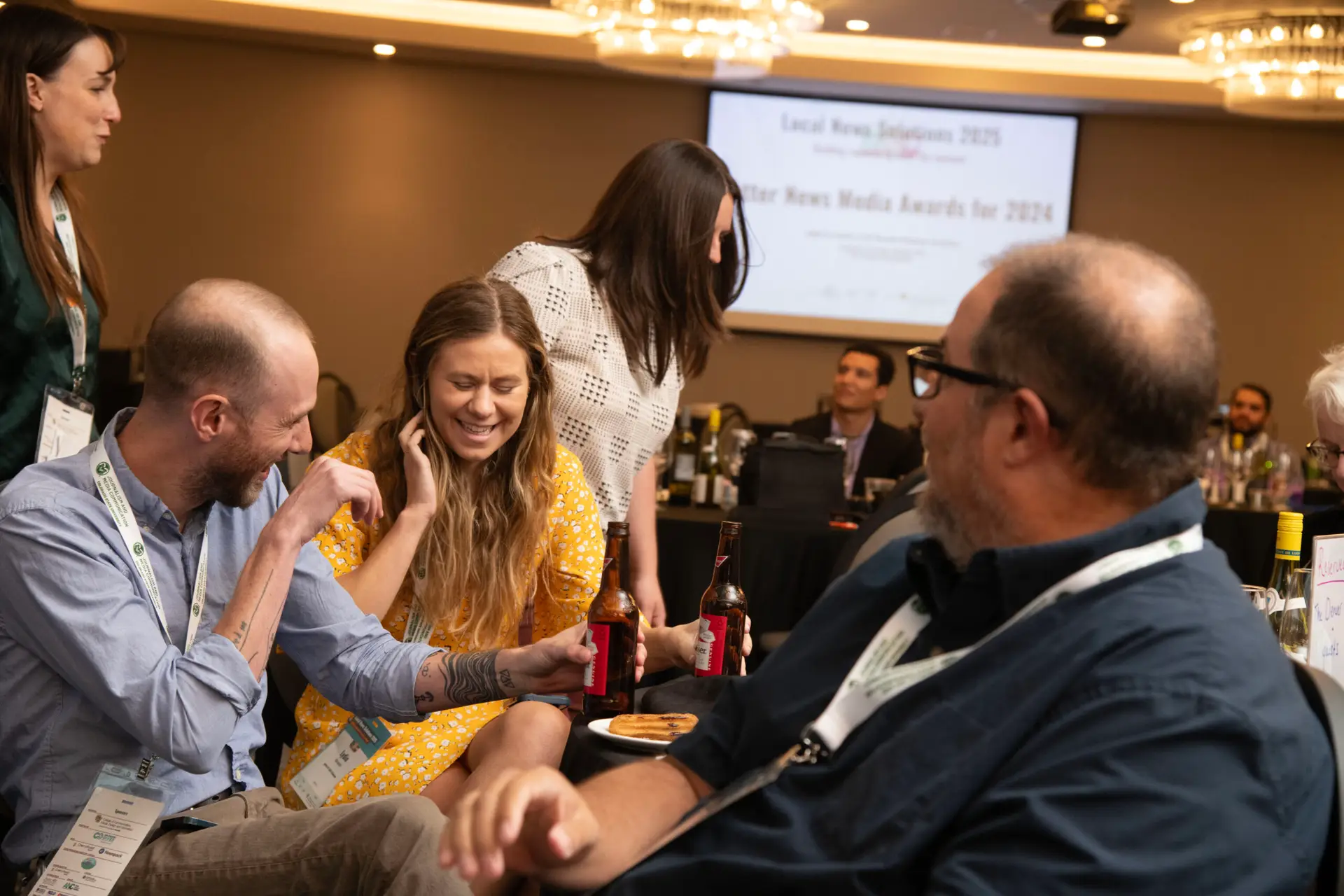 Attendees laughing together at an awards dinner table
